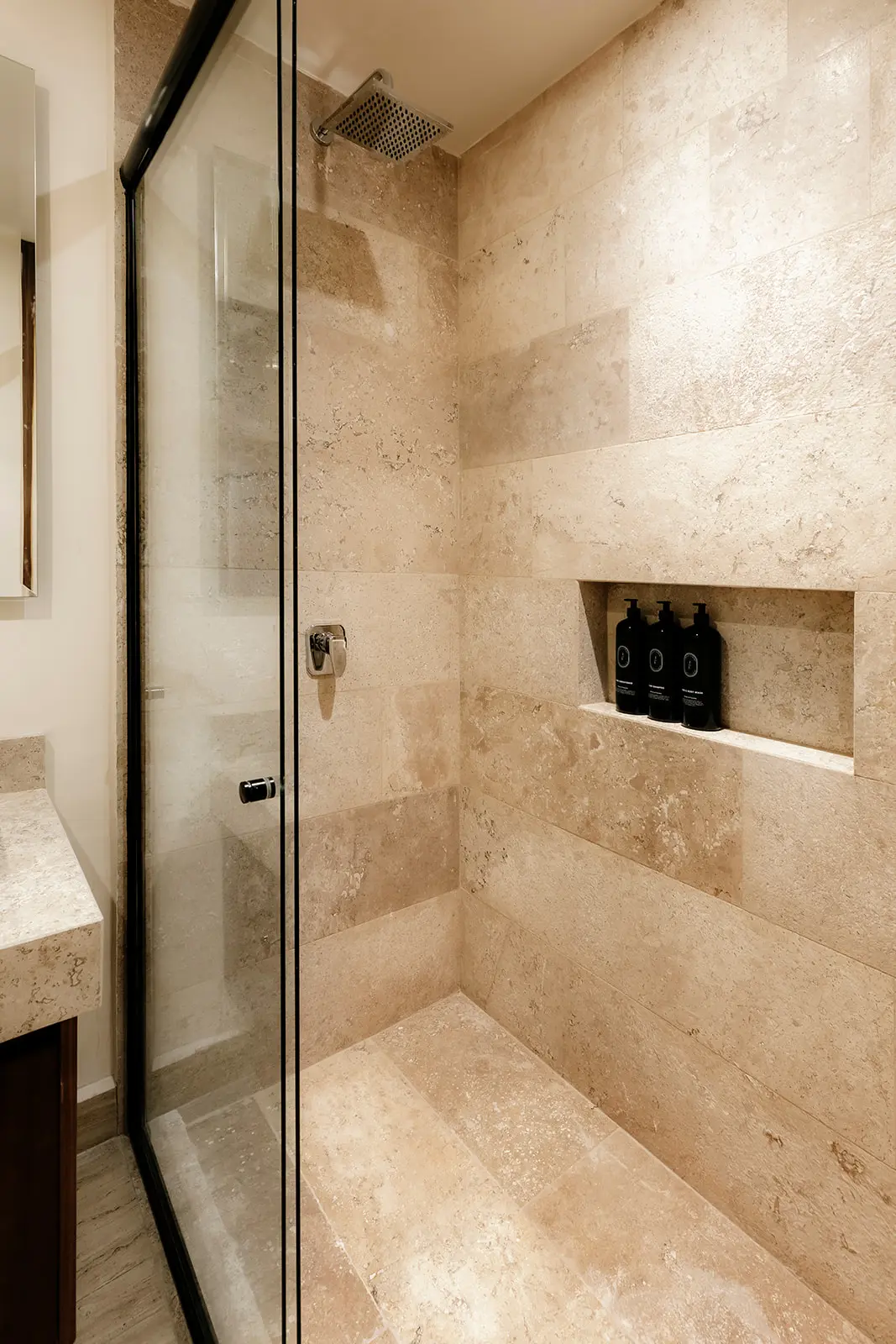 Spa-style shower with natural stone in Tulum condo bathroom