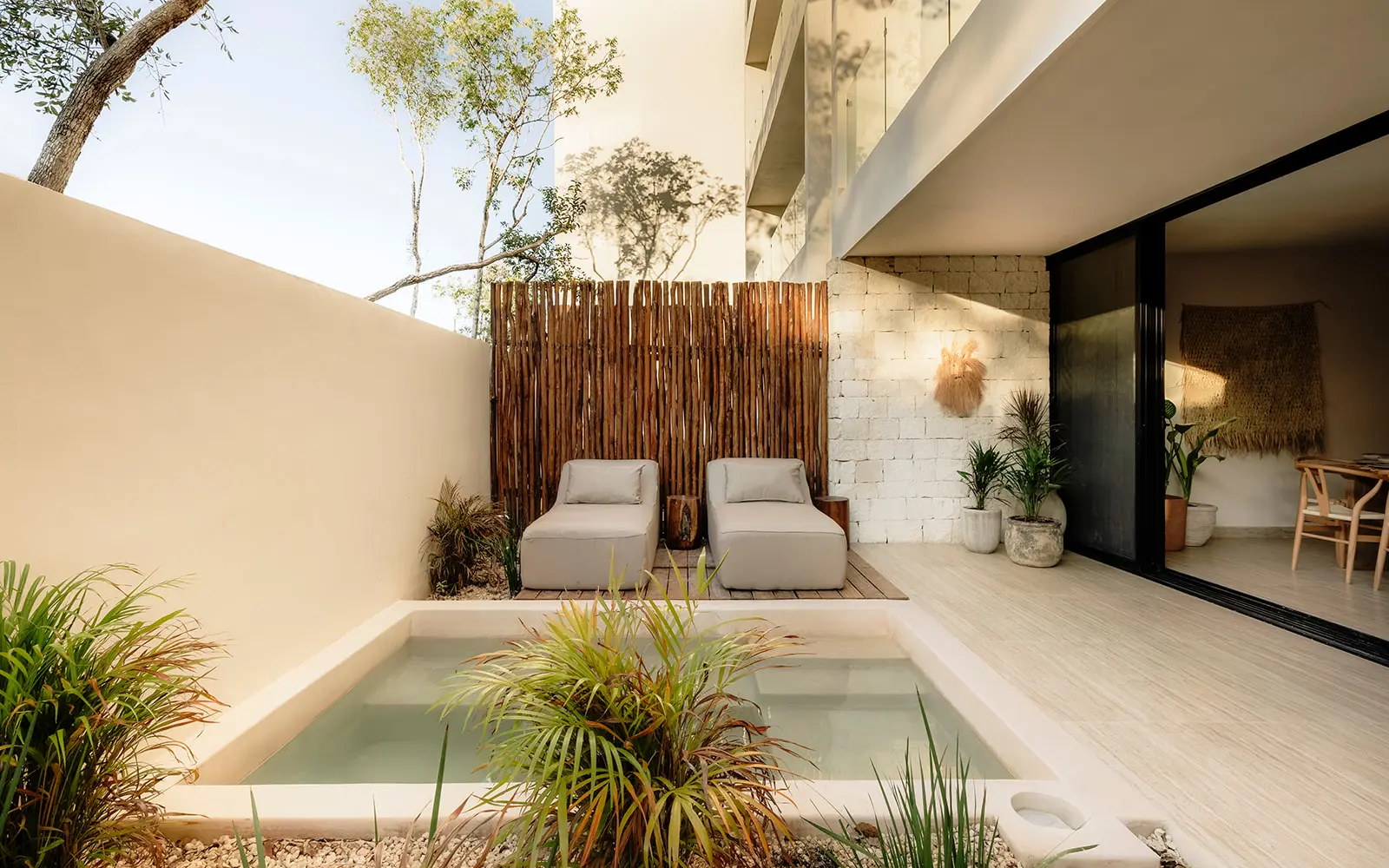 Private patio with plunge pool and lounge chairs at Aldea Zama condo