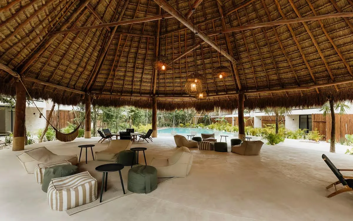 Palapa lounge area with hammocks and bean bags poolside at Samsara Tulum