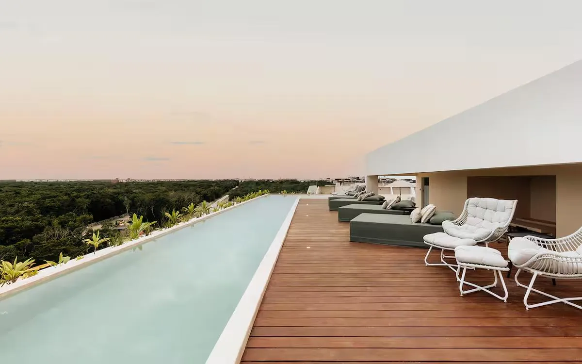 Rooftop infinity pool at sunset with jungle canopy views at Samsara Tulum